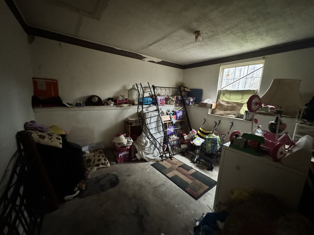 Bedroom with a damaged ceiling and belongings
